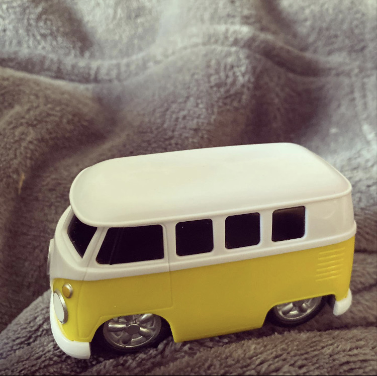 Toy yellow VW van on a grey jumper